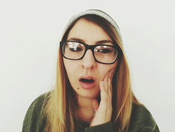 Close-up portrait of young woman against white background