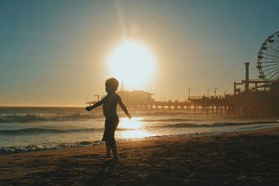 Silhouette of woman in sea at sunset