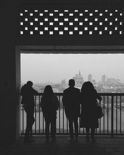 Rear view of people standing in city