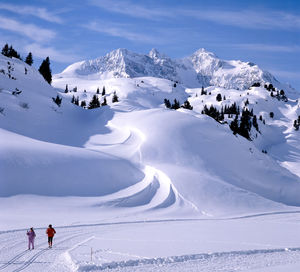 Scenic view of snowcapped mountains against sky on sunny day