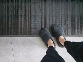 Low section of woman standing on hardwood floor