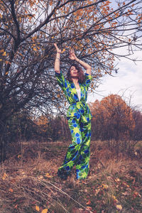 Rear view of woman standing against trees