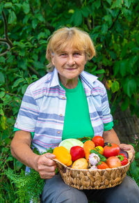 Portrait of young woman holding fruits in yard