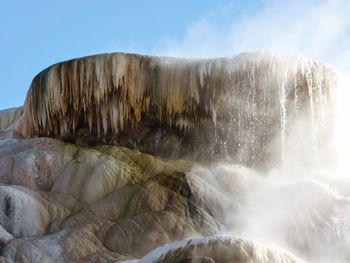 Scenic view of waterfall against sky