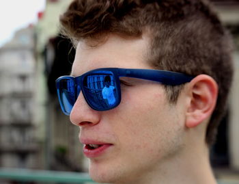 Close-up portrait of young man wearing sunglasses