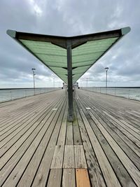 Surface level of pier on sea against sky