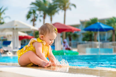 Cute baby splashing in swimming pool