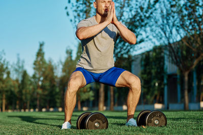 Full length of man wearing hat while sitting on grass