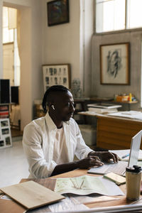 Male entrepreneur working on laptop while sitting at workplace