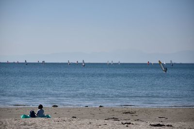 Rear view of girl relaxing at beach