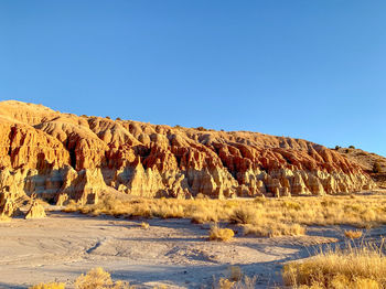 Scenic view of desert against clear blue sky