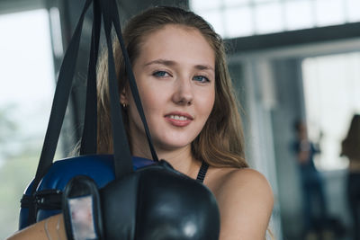 Portrait of woman holding punching bag