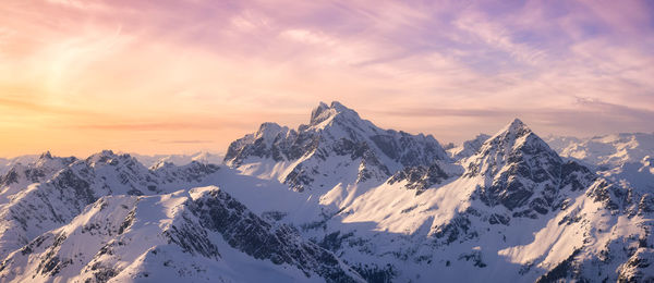 Scenic view of snowcapped mountains against sky during sunset