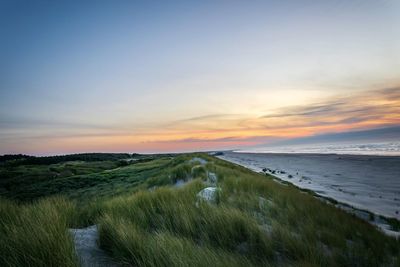 Scenic view of beach against sky during sunset