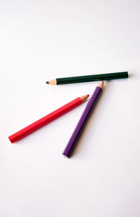 High angle view of colored pencils against white background