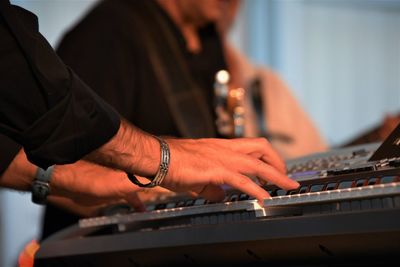 Cropped hands of man playing piano