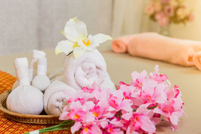 Close-up of towels and flowers on mattress