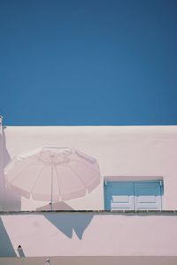 Open umbrella against house in sunny day