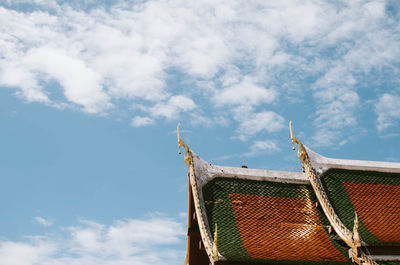 Low angle view of temple roof against cloudy sky