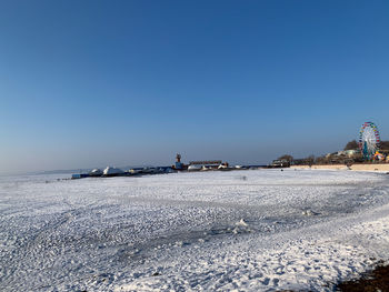 Scenic view of sea against clear blue sky during winter