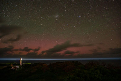 Aurora australis over  a lighthouse with a star filled night..