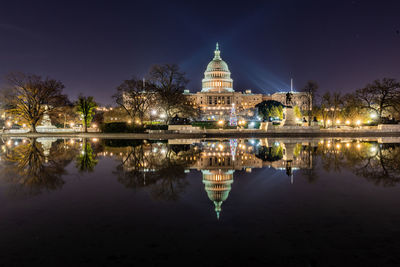 Reflection of illuminated building in lake at night