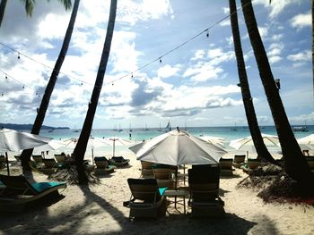 Chairs on beach against sky