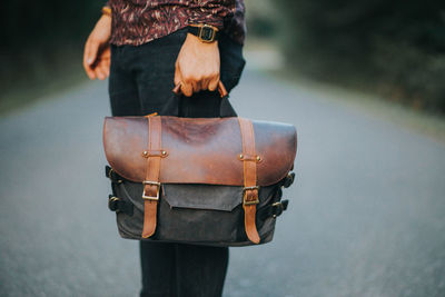 Man holding messenger bag made of canvas and brown leather 