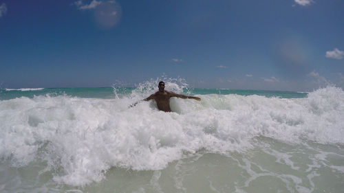 Man enjoying waves at beach against ky