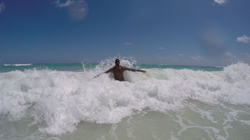 Waves splashing on sea against sky