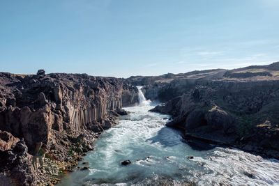 Scenic view of waterfall against clear sky