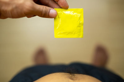 Midsection of person holding yellow camera