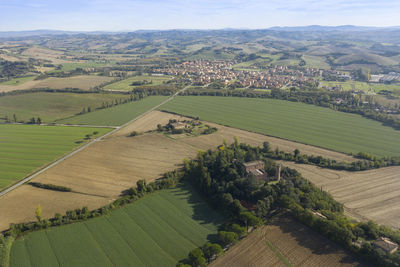 Aerial view of a castle on the hills of tuscany in the background the town of buonconvento