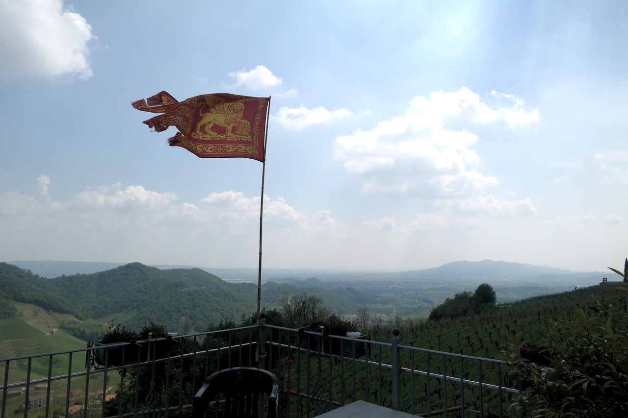 FLAG ON LANDSCAPE AGAINST SKY