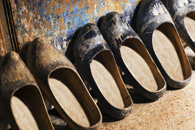 Close-up of shoes on wood against wall