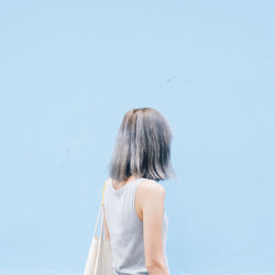 Rear view of woman standing against clear sky