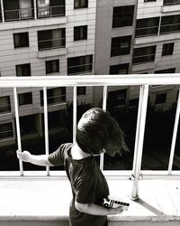 High angle view of boy playing with toy on building terrace