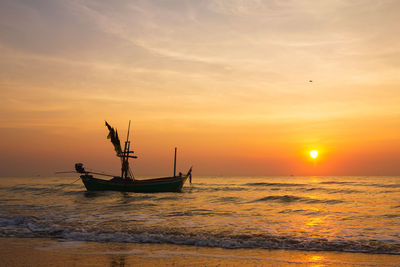 Silhouette boat in sea against sky during sunset