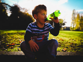 Cute boy sitting in park