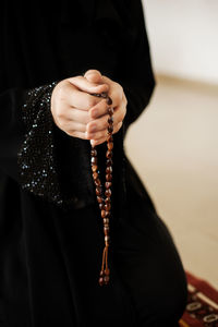 Prayer hands of a woman holding a rosary. ramadan kareem