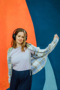 Portrait of young woman standing against yellow sweater