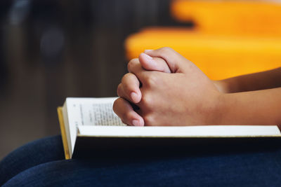 Close-up of woman hand on book