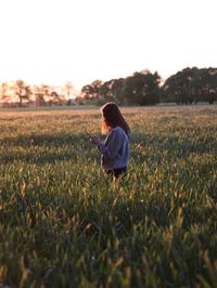 Woman on field at sunset