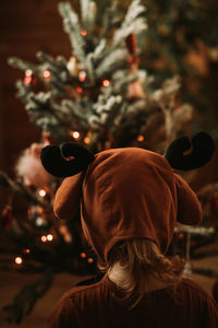 Toddler baby girl in rudolph reindeer costumes decorating christmas tree christmas tree