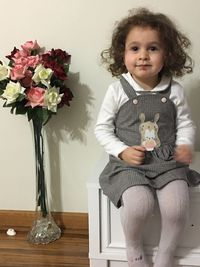 Portrait of smiling girl sitting on table