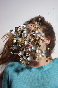 Digital composite image of woman's face covered with glass pieces on white background
