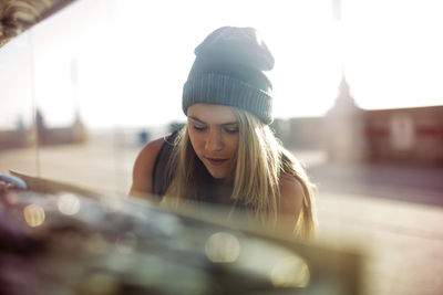 Young woman window shopping on sunny day