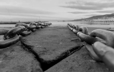 Close-up of chains on pier against sky