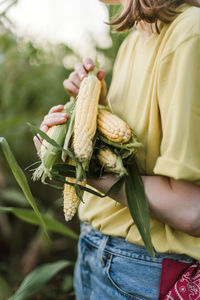Midsection of woman holding corns