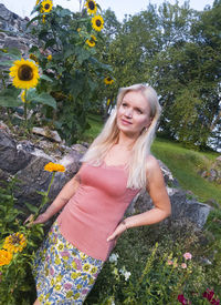 Portrait of smiling young woman standing against plants